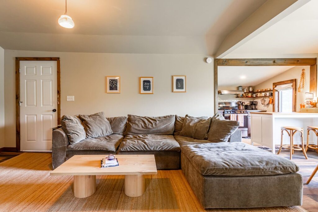 Grey sectional sofa and wood coffee table in the living room at Blue Heron cabin in Tannersville, NY