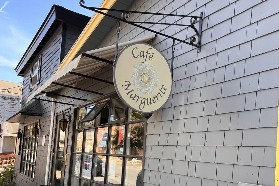 Round Café Marguerite sign over a shingled storefront on Main Street in Margaretville, NY