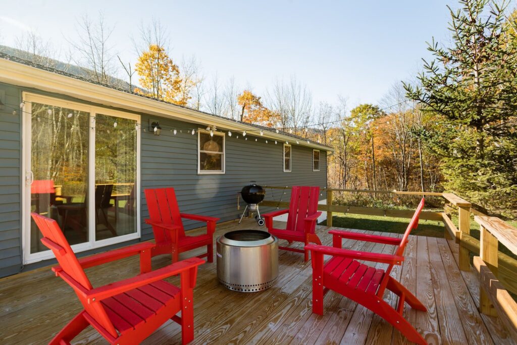 Clove Creek Cabin deck with red Adirondack chairs and a Solo Stove fire pit in Hunter, NY