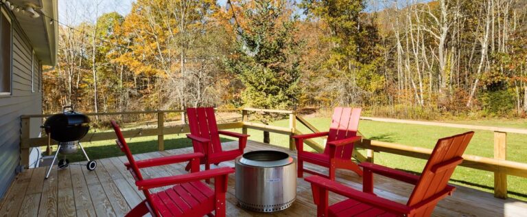 Red Adirondack chairs around a Solo Stove fire pit on the deck at Clove Creek Cabin in Hunter, NY